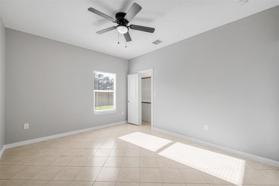 Spare room with ceiling fan and light tile patterned flooring