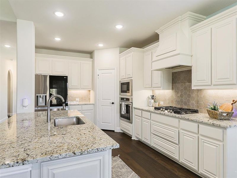 Kitchen featuring white cabinetry, appliances with stainless steel finishes, sink, and dark wood-type flooring