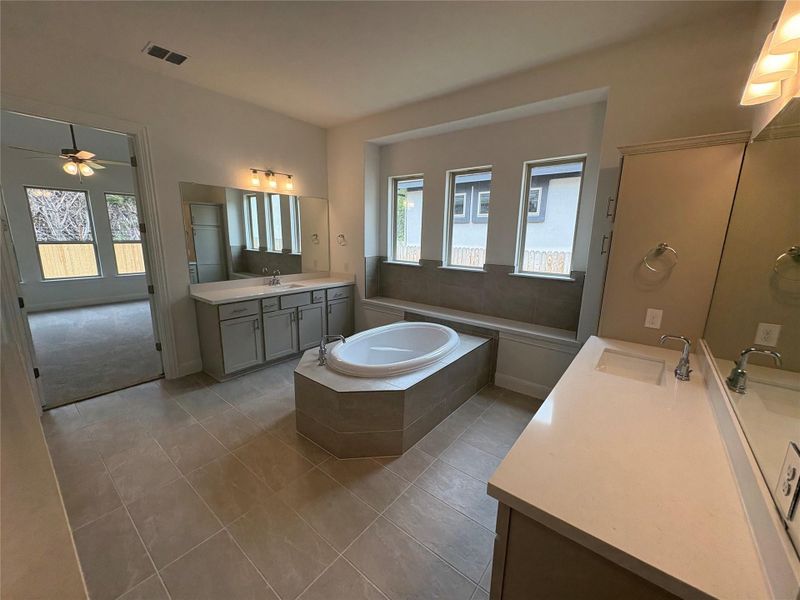 Bathroom with tile patterned floors, ceiling fan, a bath, and two vanities Bathroom with tile patterned floors, ceiling fan, a bath, and two vanities