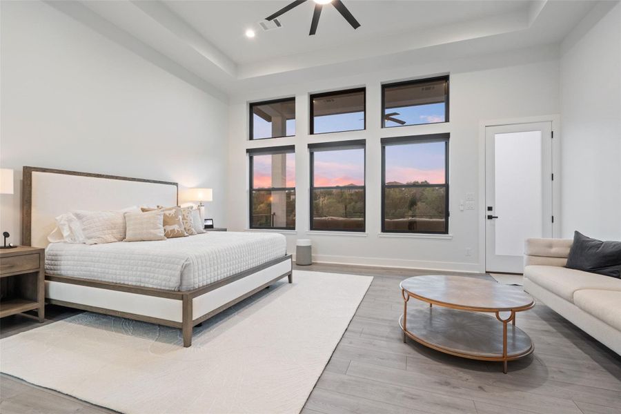 The serene primary suite is a private retreat complete with a spa-inspired bath featuring a soaking tub, oversized walk-in shower, custom-designed closet, and tranquil wooded vistas.