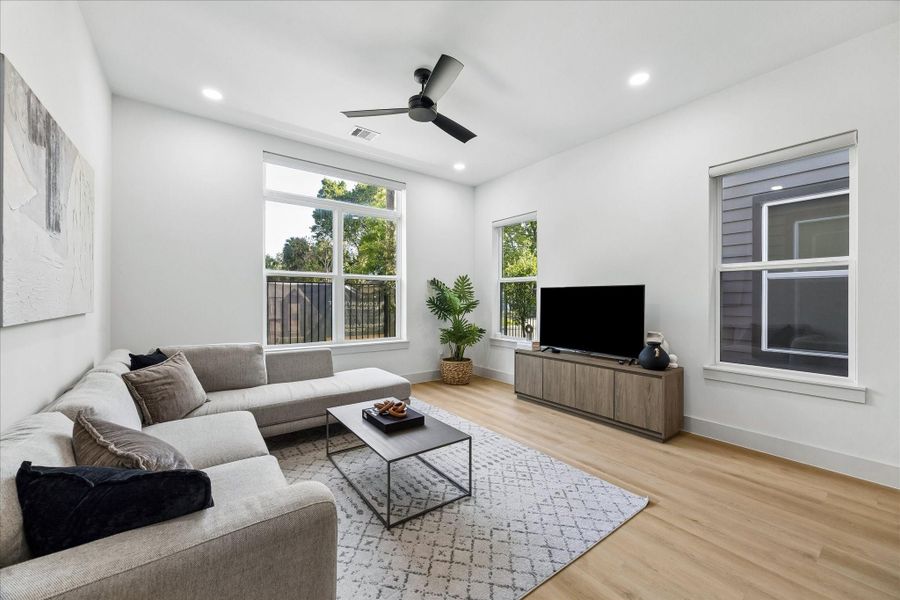 Clean architectural lines are softened by warm wood textures, fluted wall detailing, and oversized windows that flood the space with natural light.