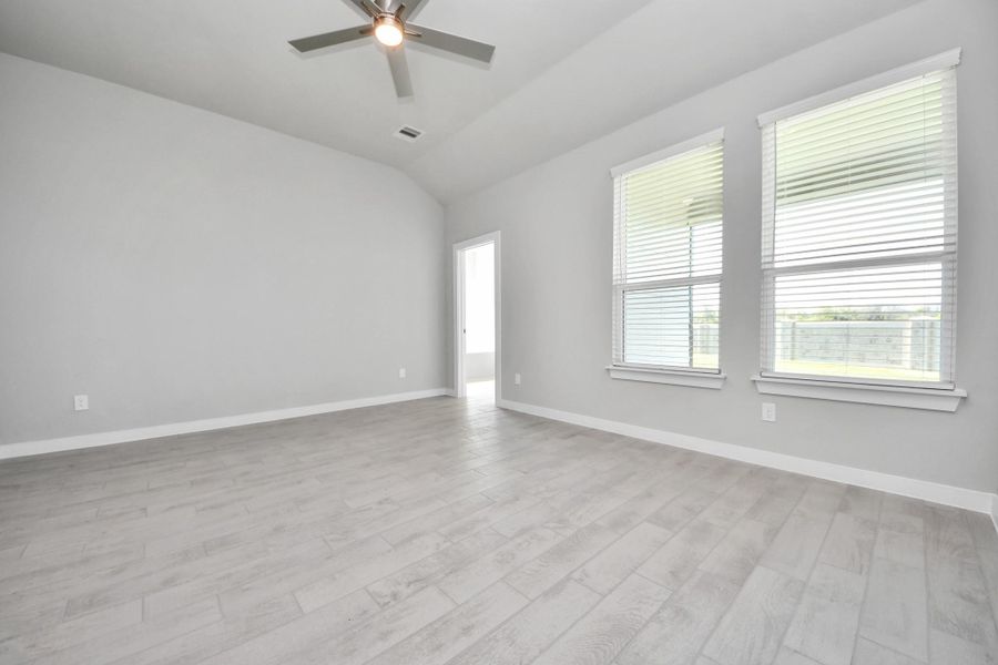 Come and unwind after a long day in this magnificent primary suite! This spacious room features beautiful flooring, warm paint, high ceilings and large windows with privacy blinds. Sample photo of completed home with similar floor plan. Actual colors and selections may vary.
