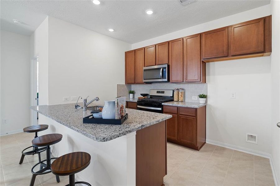 This stunning kitchen is perfect for everyday life as well as entertaining family and friends! Extra large breakfast bar is perfect for conversation or that much needed space to lay out your party spread for everyone to enjoy! Featuring stained cabinets, granite countertops, modern backsplash, stainless steel appliances, recessed lighting, and custom paint.