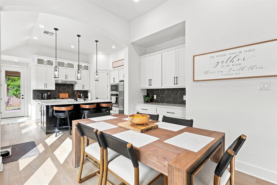 Gleaming hardwood floors and a spacious kitchen island anchor this bright open dining space.