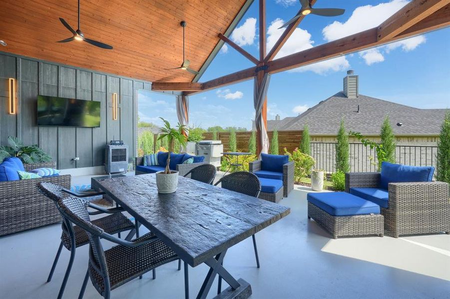 Fenced backyard with an outdoor hangout area, ceiling fan, a patio, and outdoor dining area Fenced backyard with an outdoor hangout area, ceiling fan, a patio, and outdoor dining area