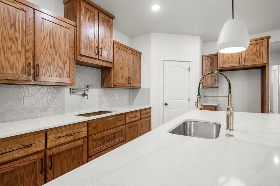 A well-appointed kitchen features a deep sink with a high-arch faucet, complementing the rich wooden cabinetry. A well-appointed kitchen features a deep sink with a high-arch faucet, complementing the rich wooden cabinetry.