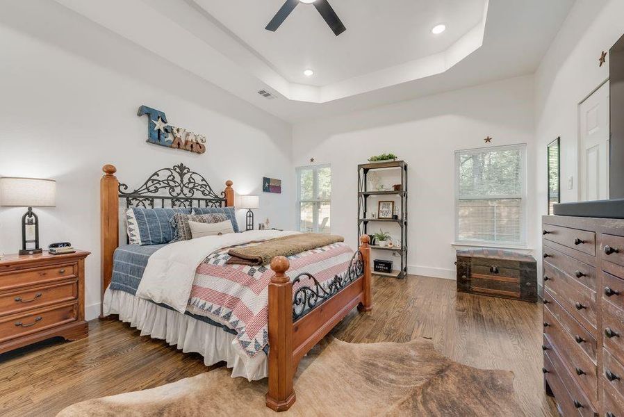 Bedroom featuring wood finished floors, ceiling fan, recessed lighting, and a raised ceiling