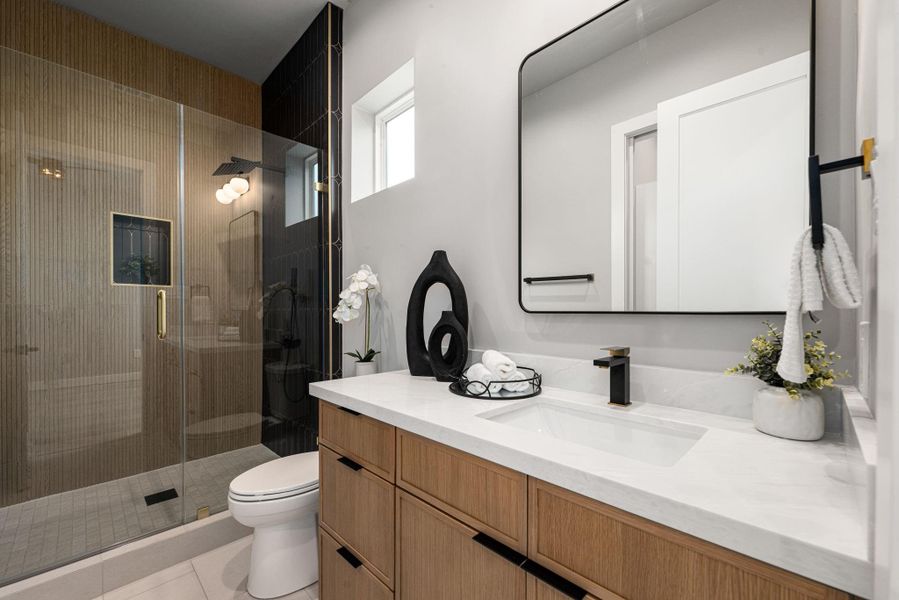 Guest bathroom featuring a glass-enclosed shower and modern fixtures Guest bathroom featuring a glass-enclosed shower and modern fixtures