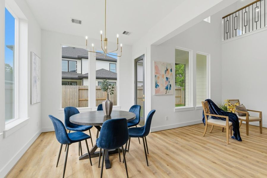 Picture windows frame the dining area, filling the space with natural light and beautiful views of the outdoors.