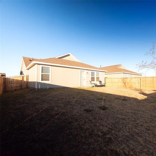 Rear view of house featuring a yard