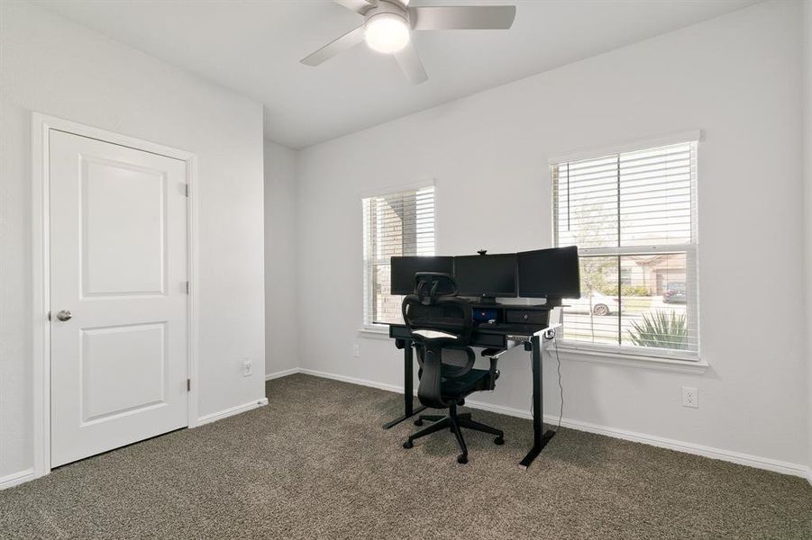 Office with carpet and a ceiling fan