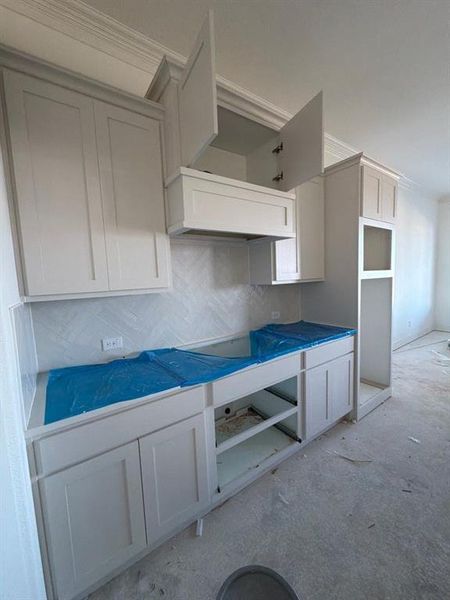 Kitchen with white cabinetry and tasteful backsplash