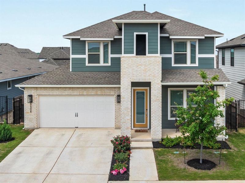 A striking modern facade pairs textured stone columns with deep teal siding. A striking modern facade pairs textured stone columns with deep teal siding.