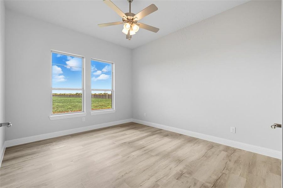 Spare room featuring light wood finished floors, a water view, and ceiling fan Spare room featuring light wood finished floors, a water view, and ceiling fan