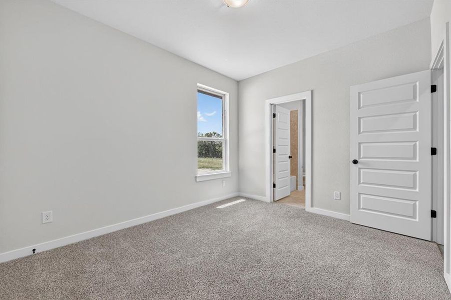 Carpeted room with light gray wall paint, white baseboards, and a single window