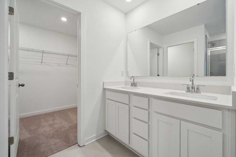 A bathroom with a sink and a shower unit.