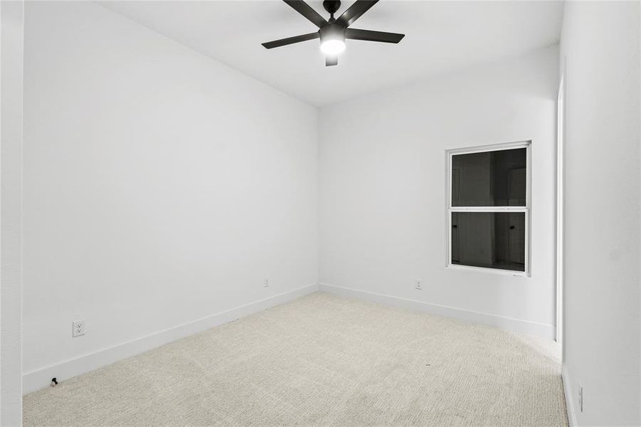 Carpeted spare room with ceiling fan