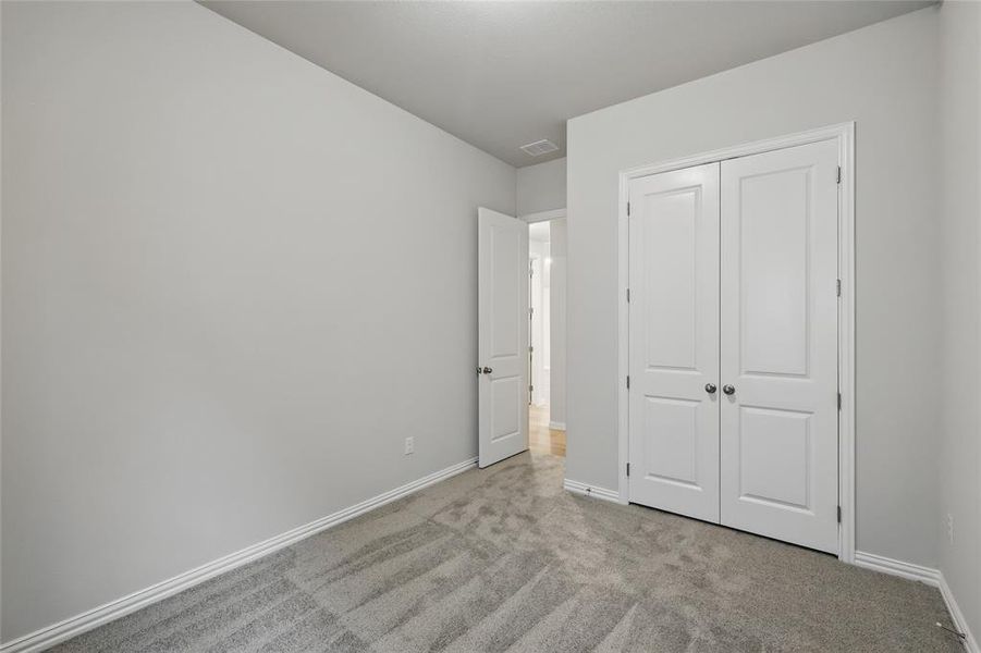 Unfurnished bedroom with carpet flooring and a closet Unfurnished bedroom with carpet flooring and a closet