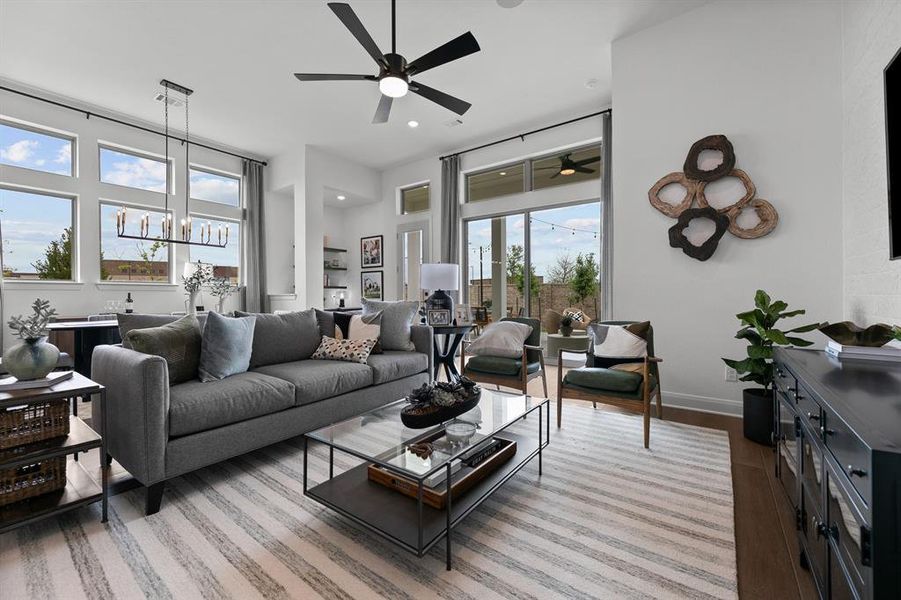 Living room featuring light wood-style flooring and suspended lighting Living room featuring light wood-style flooring and suspended lighting