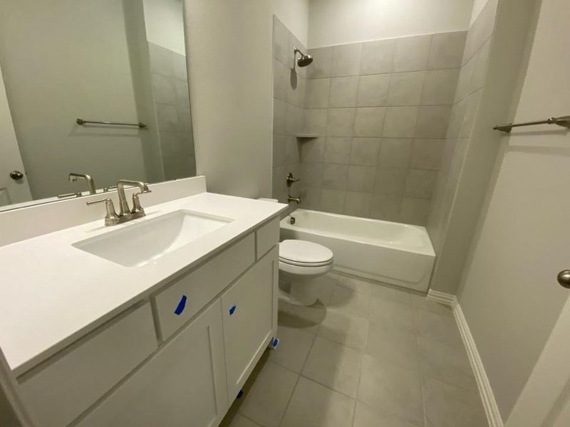 Bathroom featuring a white vanity with a rectangular integrated sink, brushed nickel faucet, and a large wall-mounted mirror Bathroom featuring a white vanity with a rectangular integrated sink, brushed nickel faucet, and a large wall-mounted mirror