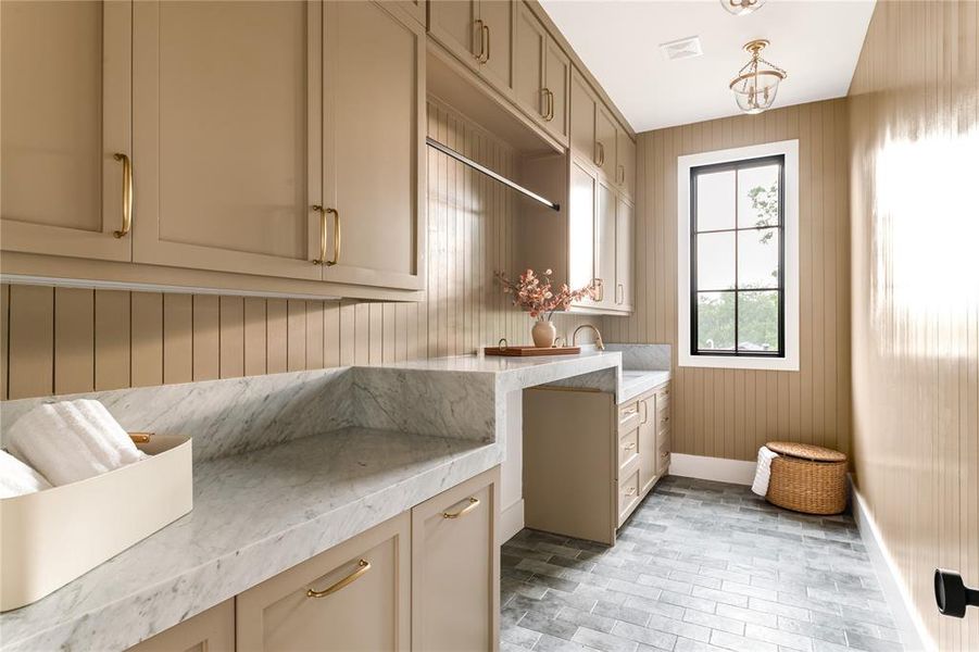 Laundry area featuring wooden walls and brick patterned flooring