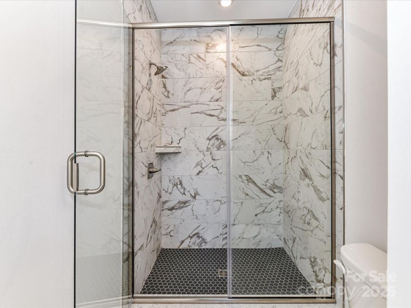 En Suite Bath With Huge Walk-In Closet and Modern Tiling.