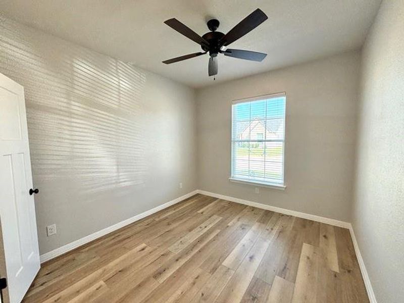 Spare room featuring ceiling fan and light wood-type flooring