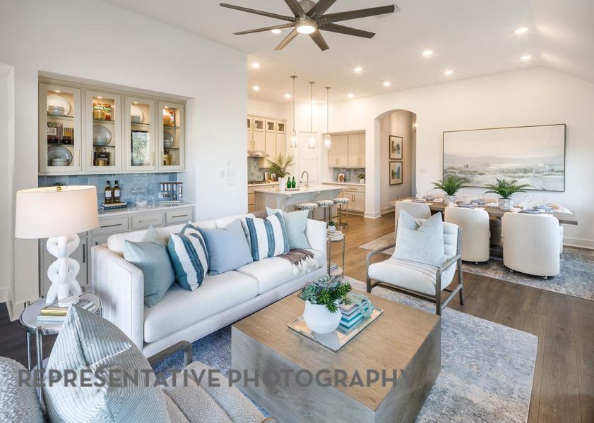 Living area featuring a ceiling fan, arched walkways, wood finished floors, vaulted ceiling, and recessed lighting Living area featuring a ceiling fan, arched walkways, wood finished floors, vaulted ceiling, and recessed lighting