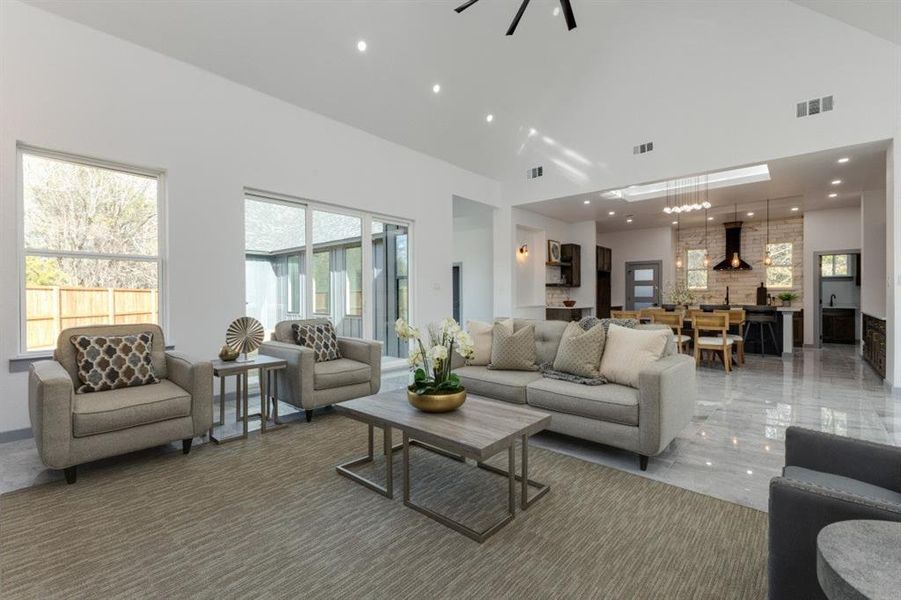 Living room featuring a high ceiling and a healthy amount of sunlight