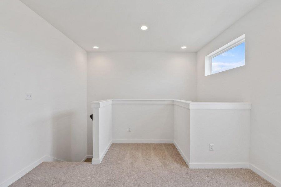 Unfurnished room with light colored carpet and recessed lighting