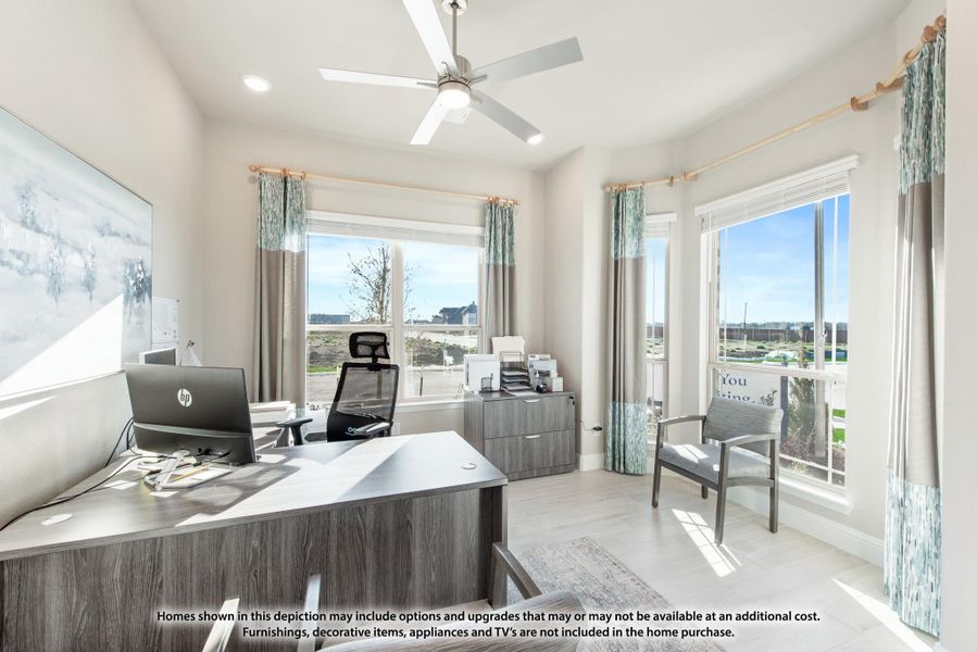 Home office with wood desk, ceiling fan, and large windows with natural light Home office with wood desk, ceiling fan, and large windows with natural light