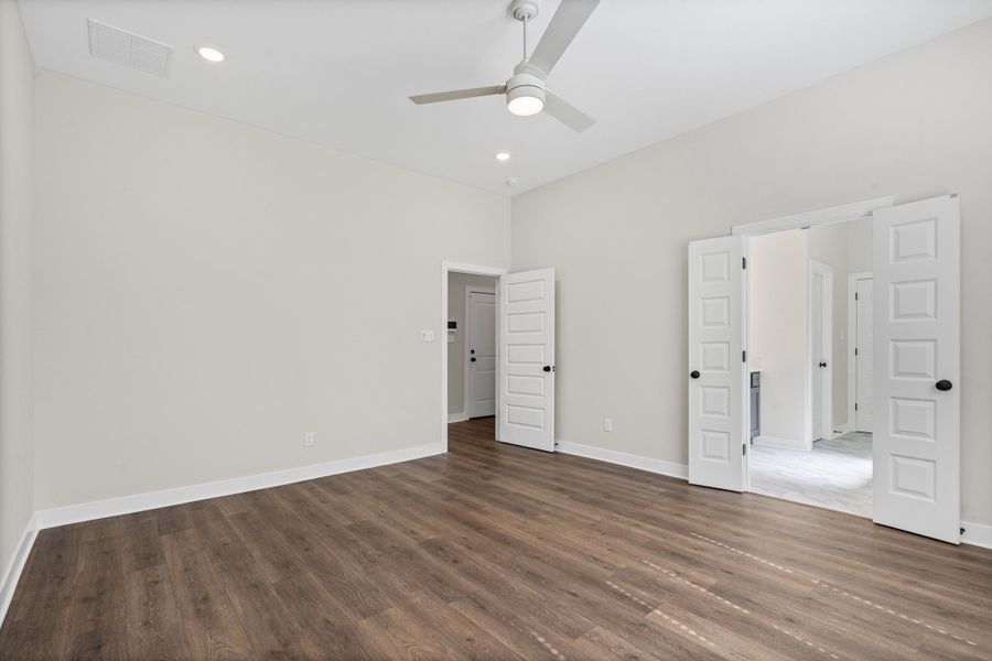 Unfurnished bedroom with a ceiling fan, dark wood finished floors, and recessed lighting Unfurnished bedroom with a ceiling fan, dark wood finished floors, and recessed lighting