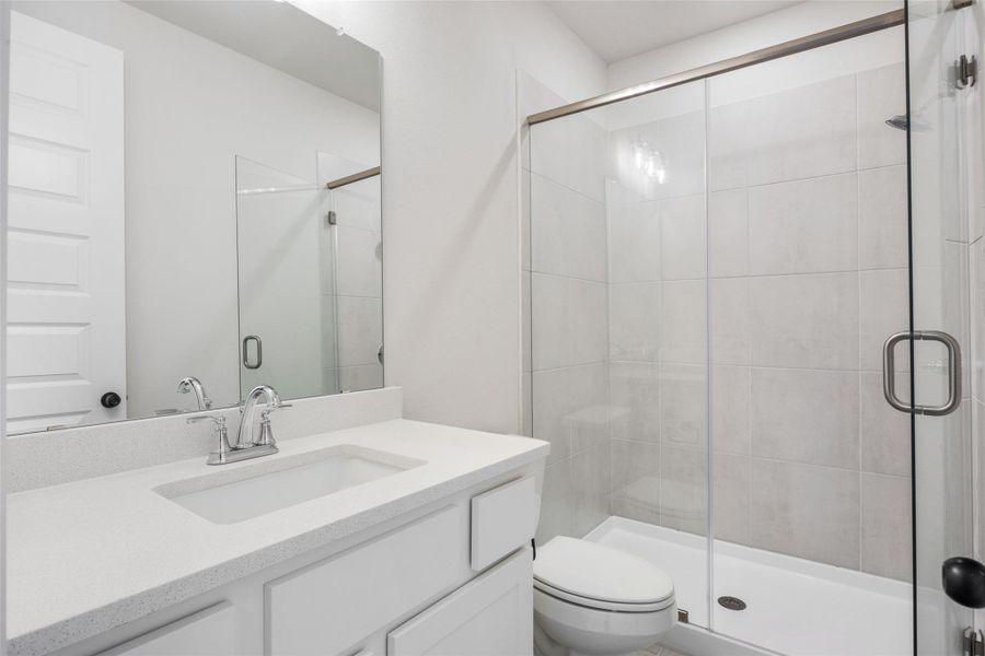 Full bath with a shower stall and vanity