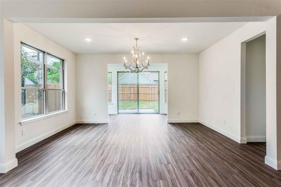 Spare room featuring dark hardwood / wood-style flooring and a chandelier