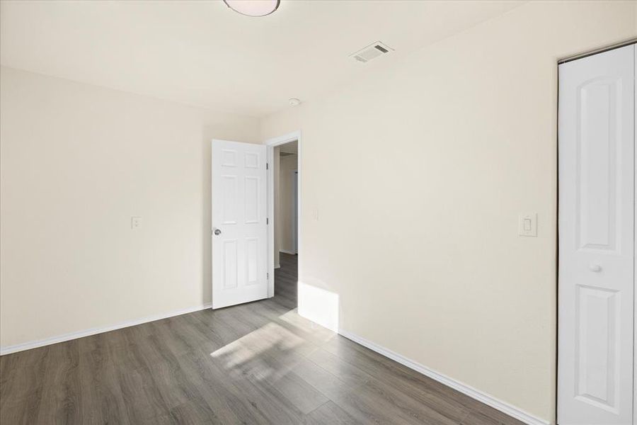 Spare room with dark wood-type flooring