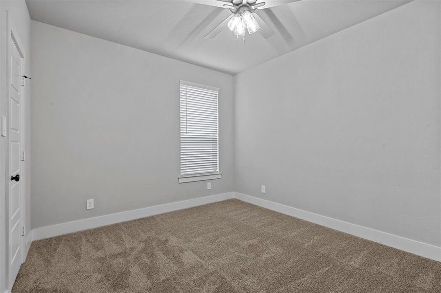 Carpeted empty room with ceiling fan