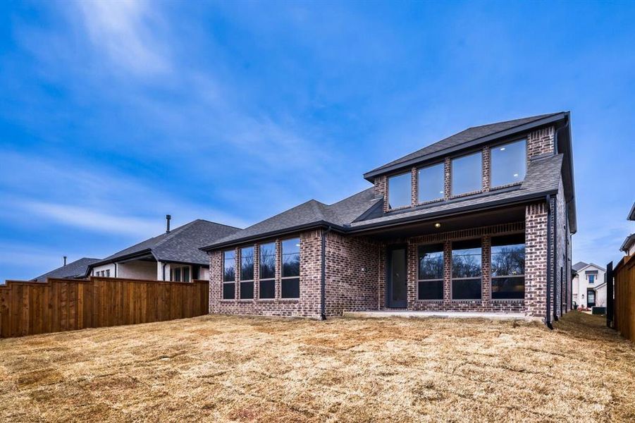 Back of house with a patio area, brick siding, and roof with shingles