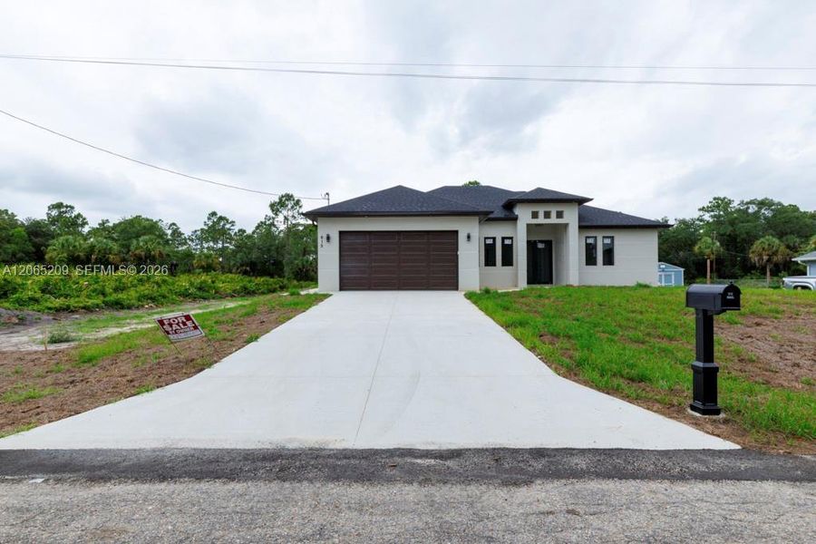 Front exterior of a new home in , Lehigh Acres, FL, highlighting curb appeal (Image 26).