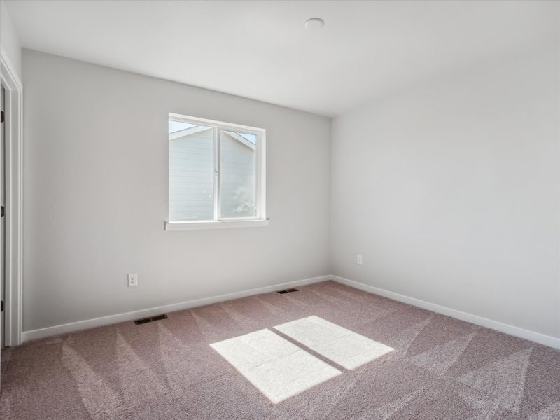 A room with a rug and a window.
