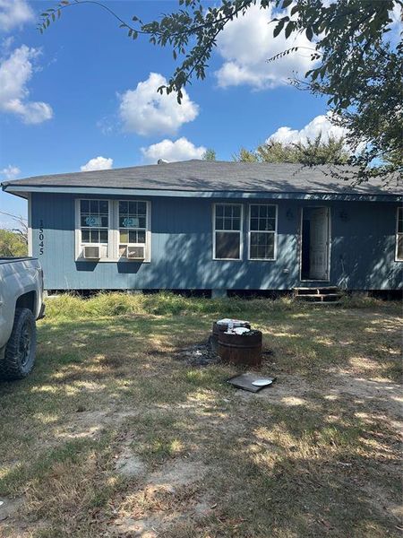 View of front of house featuring roof with shingles, entry steps, and a front yard