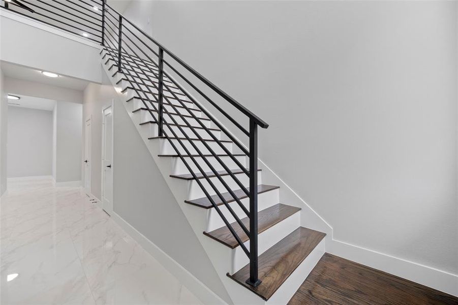 Stairway with marble finish floor and baseboards