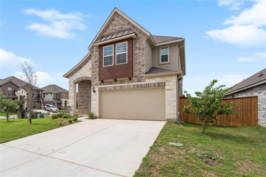 View of front of property featuring concrete driveway, an attached garage, stone siding, roof with shingles, and a residential view View of front of property featuring concrete driveway, an attached garage, stone siding, roof with shingles, and a residential view