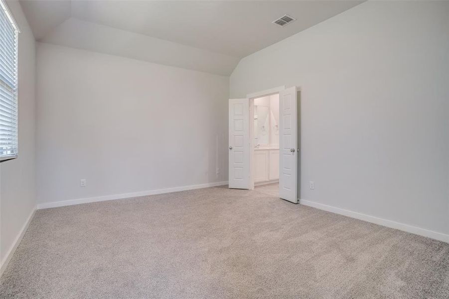 Spare room with light colored carpet and vaulted ceiling