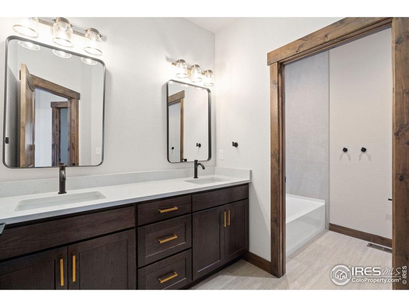 Upstairs bathroom with quartz countertops, double sinks, and tub/shower