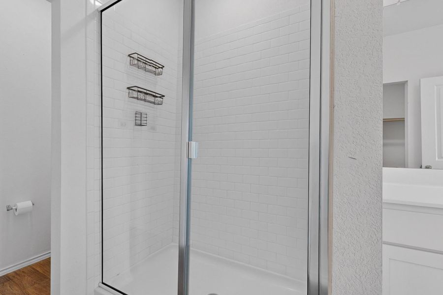 Clean subway tile walls line a glass-enclosed walk-in shower in this modern bathroom. Clean subway tile walls line a glass-enclosed walk-in shower in this modern bathroom.