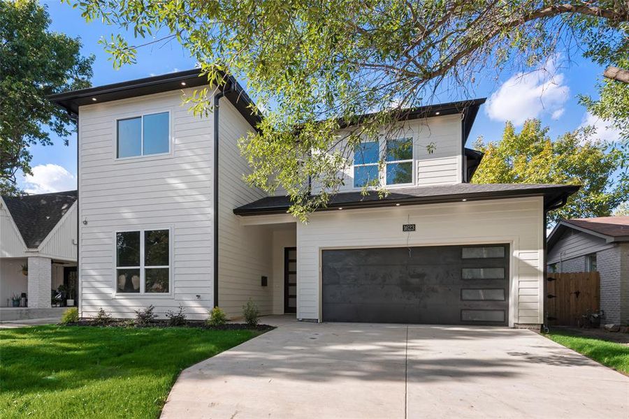 View of front of house featuring a front yard and a garage