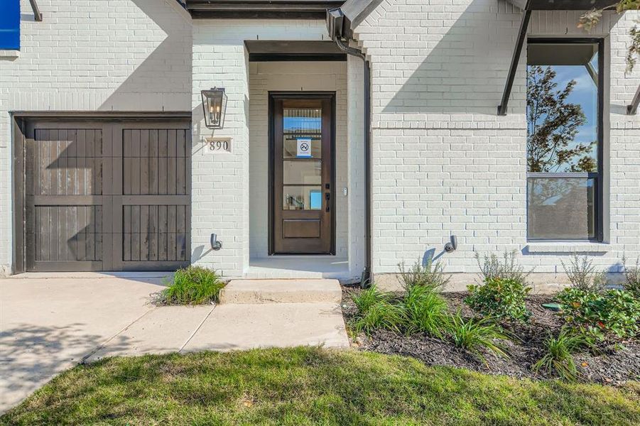 View of exterior entry featuring brick siding and driveway View of exterior entry featuring brick siding and driveway