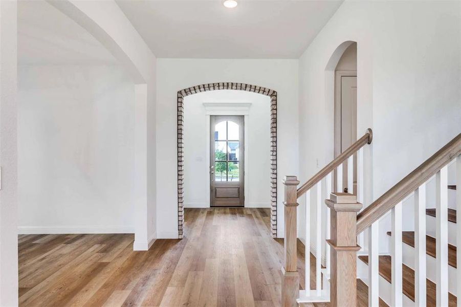 Foyer with light wood-type flooring, arched walkways, and recessed lighting Foyer with light wood-type flooring, arched walkways, and recessed lighting