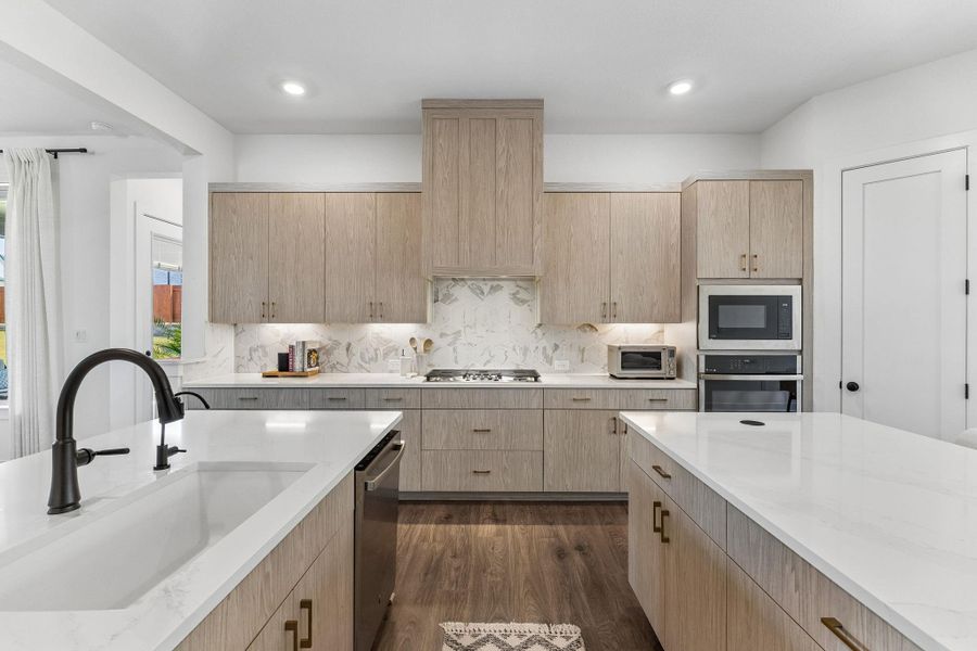 Gleaming stone countertops and custom cabinetry define this thoughtfully designed culinary space.