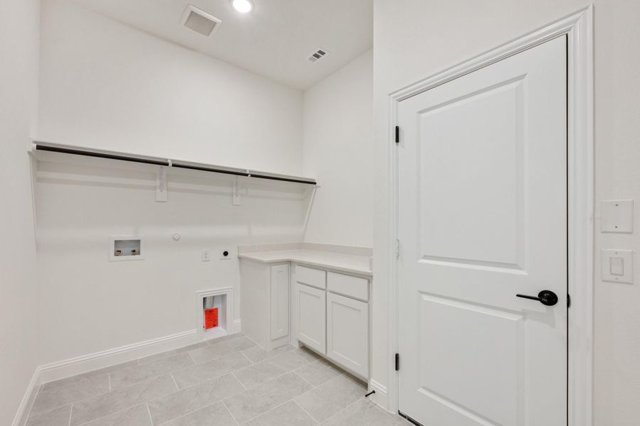 Laundry room with white cabinets, built-in shelf, washer hookups, and tile floor Laundry room with white cabinets, built-in shelf, washer hookups, and tile floor